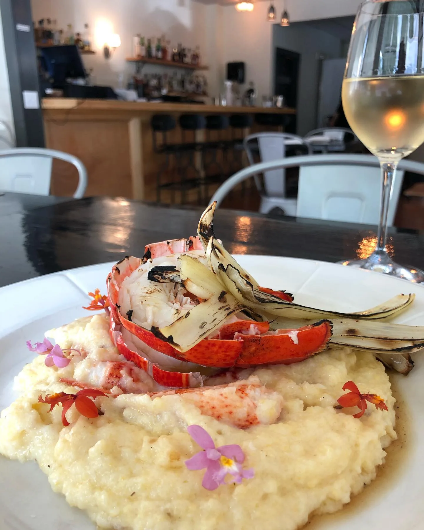 Lobster tail served over creamy risotto, garnished with an edible flower.